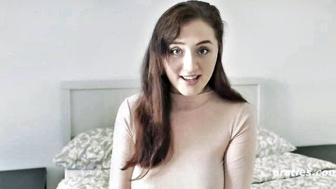 Smiling German amateur babe with brown hair in pink turtleneck sweater on bed