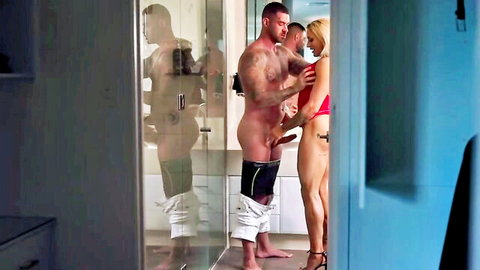 Blonde woman with two muscular men in explicit bathroom threesome