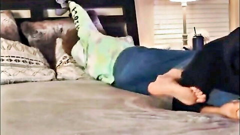 Gay foot worship with dom's neon green socked foot and bare sole pressed against sub's face on bed