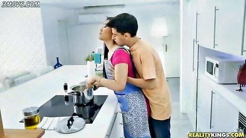 Katana in apron embraced by stepbro Jordi in kitchen scene