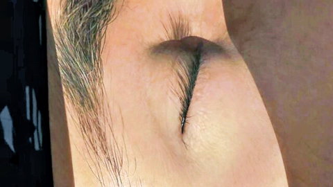 Intense close-up of woman's eye with dramatic dark eyeliner in adult video