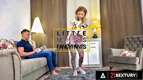 Blonde teen Flora Fairy in floral top and pink leggings teasing man on couch
