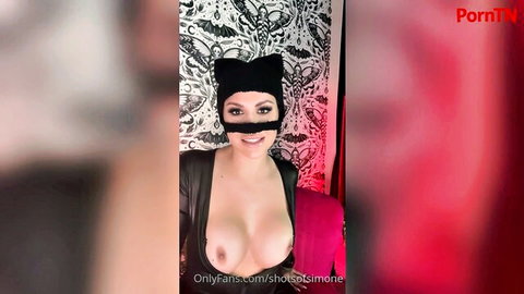 Busty babe in black cat mask and leather exposing massive bare tits smiling seductively