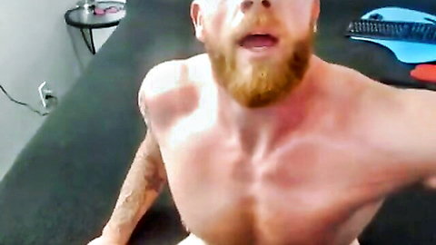 Muscular bearded man with tattoos leans in POV style, shirtless tease