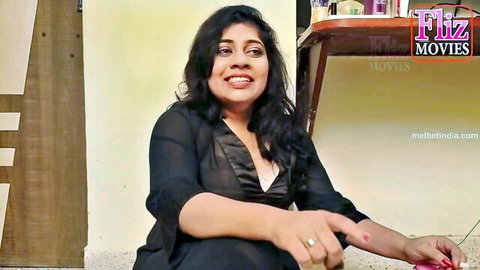 Curvy Indian woman in sheer black top smiling seductively