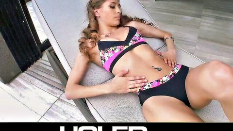 Rebel Lynn in pink bikini lounging seductively poolside