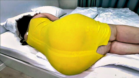 Curvy Asian MILF in tight yellow dress exposing huge round ass on bed