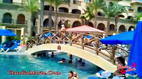Blonde BBW Claudia Marie in bikini at sunny resort pool bridge with swimmers