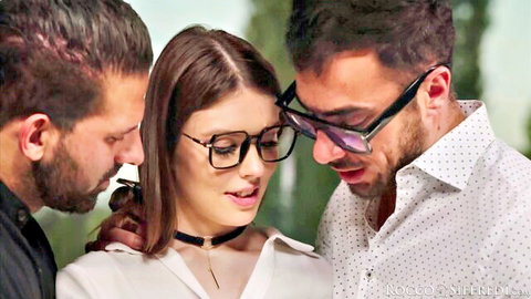 Brunette woman in glasses and choker leans in close with two men for intense threesome tease