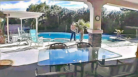 Sunny backyard pool patio with blue swimming pool, hot tub, lounge chairs and man standing nearby.