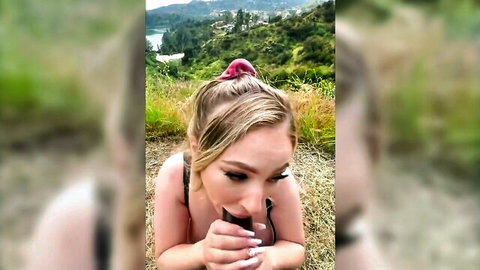 Blonde woman in black bikini top posing seductively outdoors, interracial theme hinted