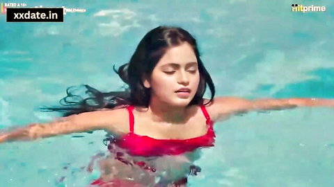 Sexy Indian babe in red bikini floating in pool with wet hair
