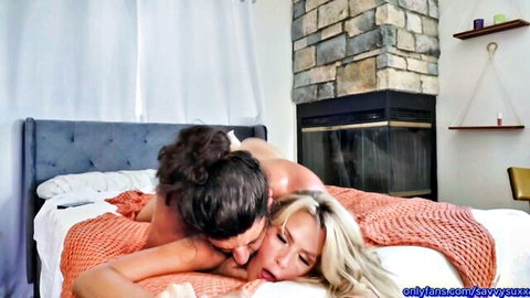 Nude hunk passionately kissing busty blonde babe's mouth on cozy bed