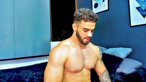 Muscular hunk Paul Phoenix shirtless in bedroom, curly hair and beard