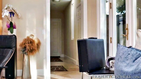 Maya Woulfe in elegant home with orchids and suitcase, teasing trans anal scene