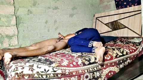 Dark-skinned man lies on bed with blue pants pulled down to ankles spreading bare legs amateur homemade