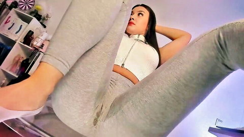 Asian woman in wet gray yoga pants spreading legs teasingly