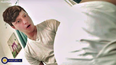 Excited young Caucasian man in white t-shirt staring at bed in stepmom fantasy scene