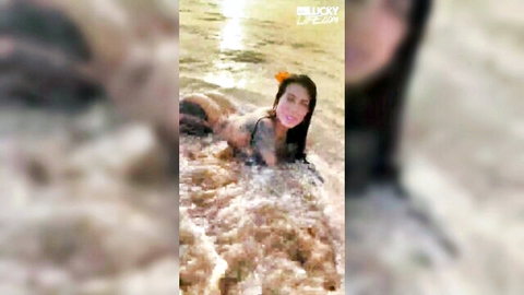 Sexy Japanese babe in bikini lounging in shallow outdoor water