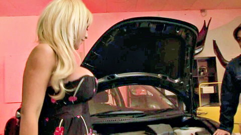 Busty blonde in sexy dress bent over car hood with man, teasing foursome vibe