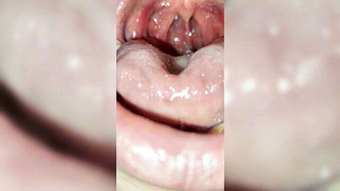 Close-up of open mouth swallowing white gummy on tongue
