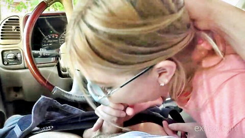 Blonde woman in glasses giving road head blowjob in car