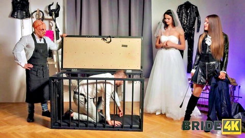 Bride and latex mistress watch cuckold husband locked naked in BDSM dog cage