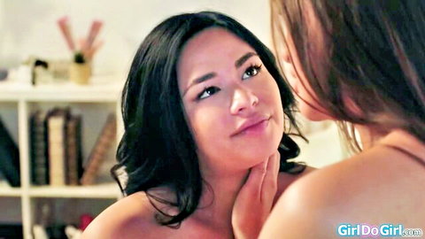 Two topless Asian lesbians intimately touching faces and smiling seductively