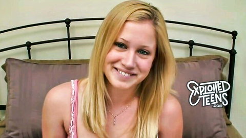 Smiling blonde teen with cleavage in pink top on bed for exploited teens casting