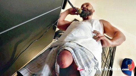 Bearded muscular redneck exposes thick cock and balls while talking on phone in bunk cage