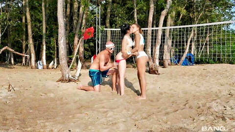 Two men groping asses of young bikini brunettes on beach volleyball court