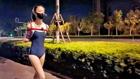 Chinese girl in blue swimsuit with BDSM straps running outdoors at night exhibitionism