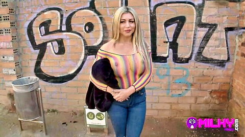 Busty blonde Carla Boom posing in striped top and jeans outdoors