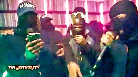 Masked group in 410 Crib Session, holding mics and phones in dim room