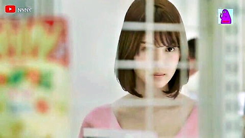 Asian girl with short hair in pink top gazing through window, nightlife vibe