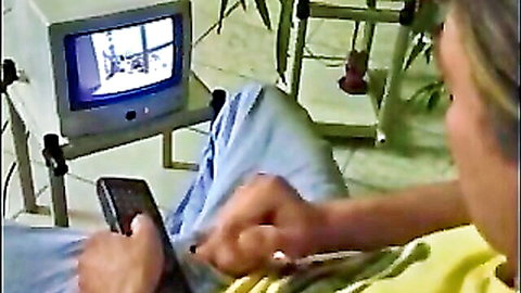 Blonde woman in casual clothes watching TV in relaxing scene