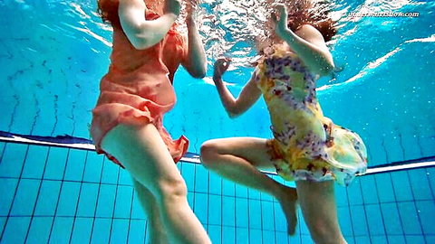 Two sexy girls in sheer wet dresses floating underwater in pool exposing thighs and curves