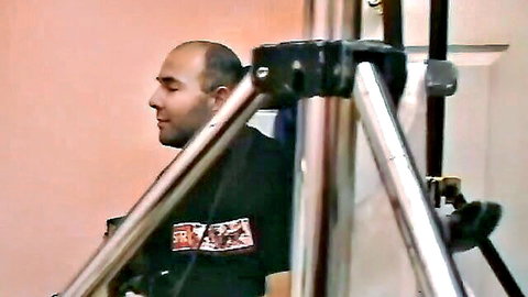 Bald director in black shirt overseeing sexy brunette's casting audition