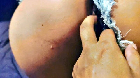 Hand groping massive bare ass cheek from ripped denim shorts closeup
