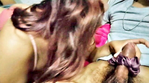 Brunette woman grips thick erect cock with purple ribbon in intense handjob closeup