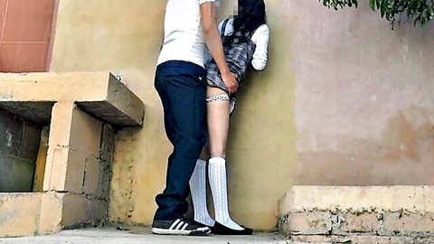 Guy gropes exposed wet pussy of bent-over Latina schoolgirl in plaid skirt outdoors against public wall
