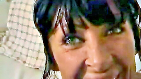 Seductive tanned MILF with wet black hair and piercing green eyes stares hungrily