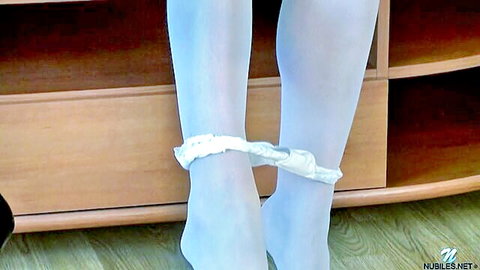 Skinny girl spreads legs pulling down white lacy panties in sheer stockings