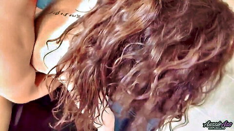Sexy brunette with long wavy hair and shoulder tattoo teasing in closeup amateur shot