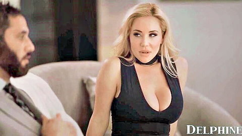 Busty blonde Savannah Bond in low-cut black dress with choker on couch
