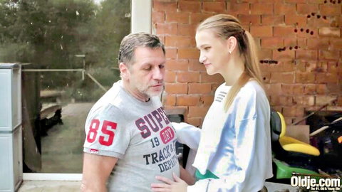 Older daddy touches sweet blonde teen in tracksuit outdoors