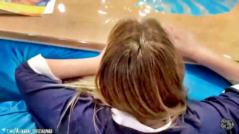 Russian MILF with glasses in blouse and skirt, lying face down on blue surface