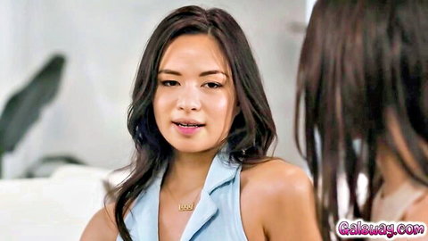Two sexy Asian brunettes in tight blue halter tops flirting intimately close-up