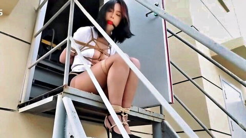Bound Chinese girl in outdoor BDSM exhibitionism pose