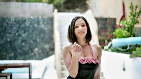 Eve Sweet in sexy black bikini smiling poolside, erotic solo tease